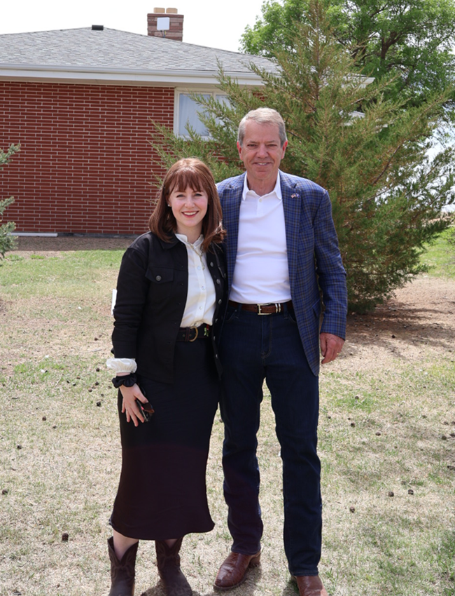 NTIA Administrator Arielle Roth and Nebraska Gov. Jim Pillen standing in front of a household.