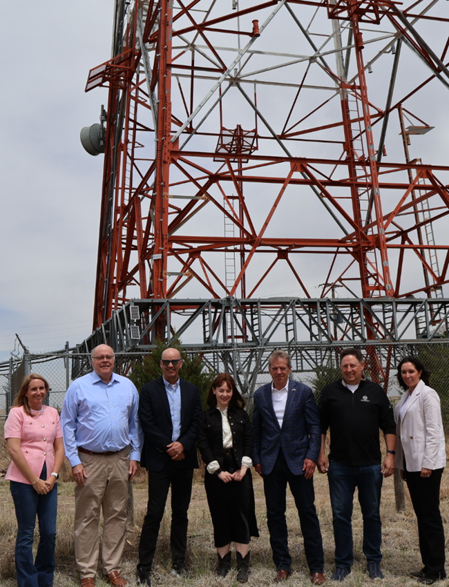 Officials standing in front of a wireless tower in Nebraska.